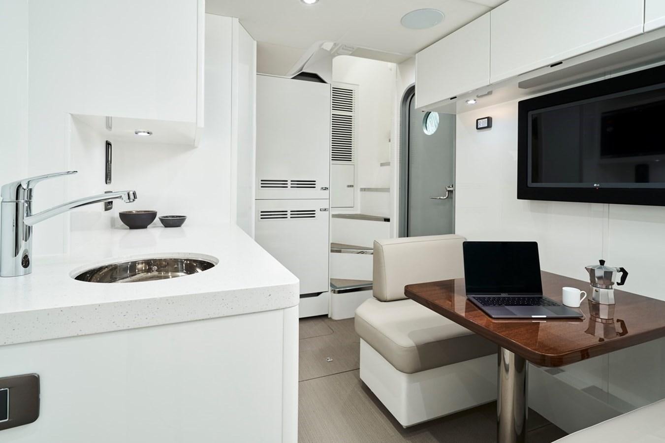 a kitchen with a laptop and a sink aboard ROVAL Yacht for Sale