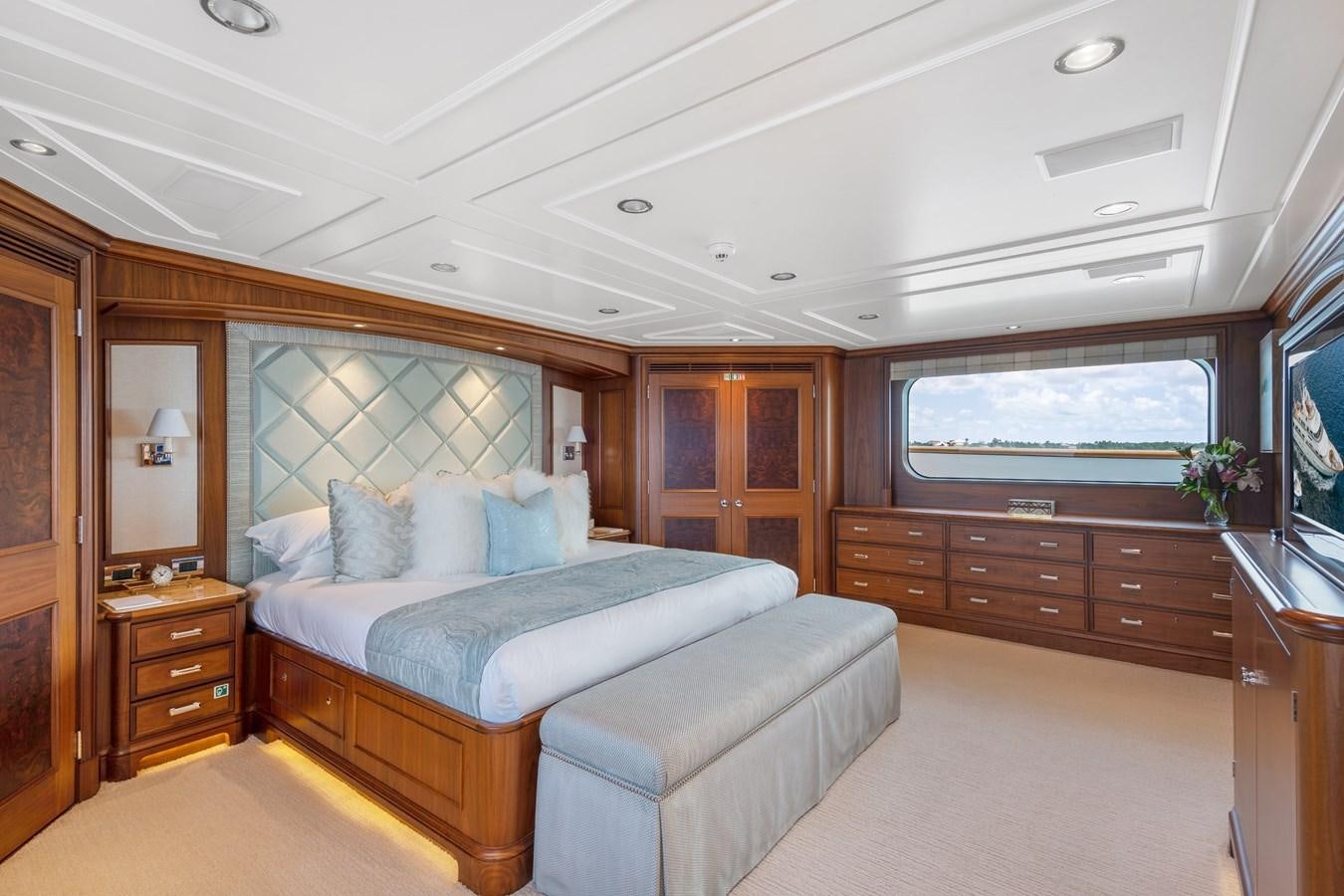 a bedroom with a bed and a dresser aboard BIG EASY Yacht for Charter