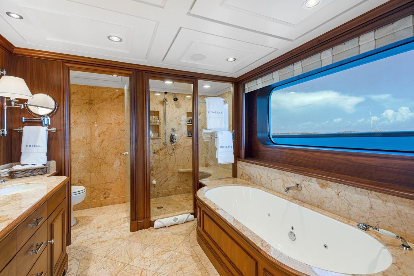 a bathroom with a bathtub and a large mirror aboard BIG EASY Yacht for Charter