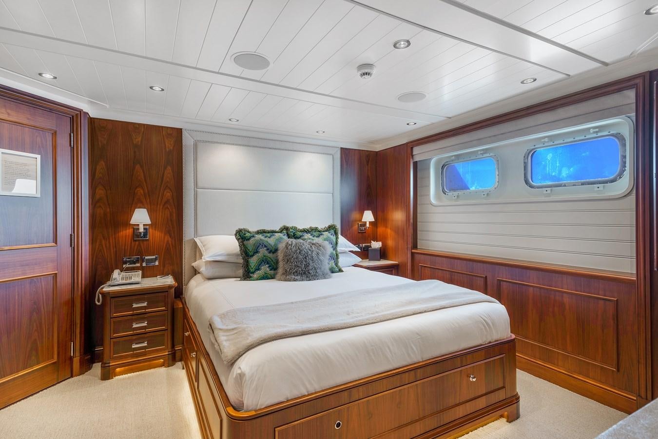 a room with a bed and a television aboard BIG EASY Yacht for Charter