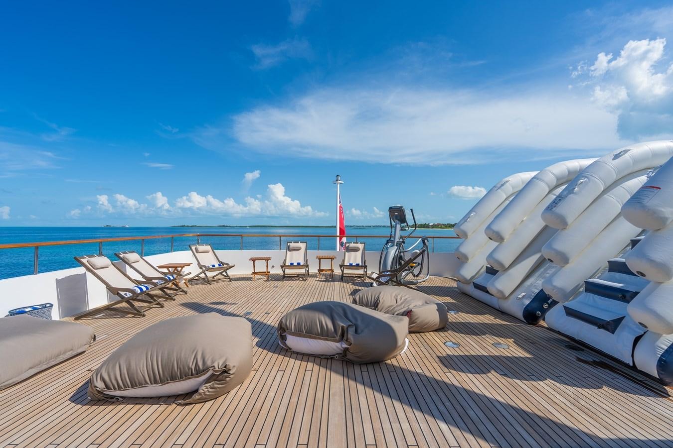 a deck with chairs and a body of water in the background aboard BIG EASY Yacht for Charter