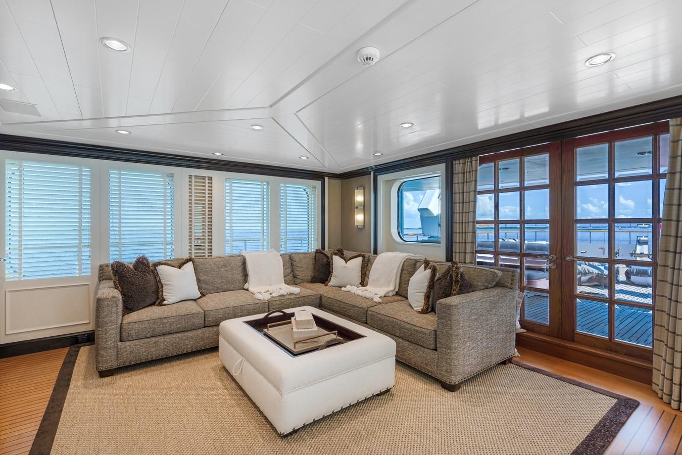 a living room with a couch and a large window aboard BIG EASY Yacht for Charter