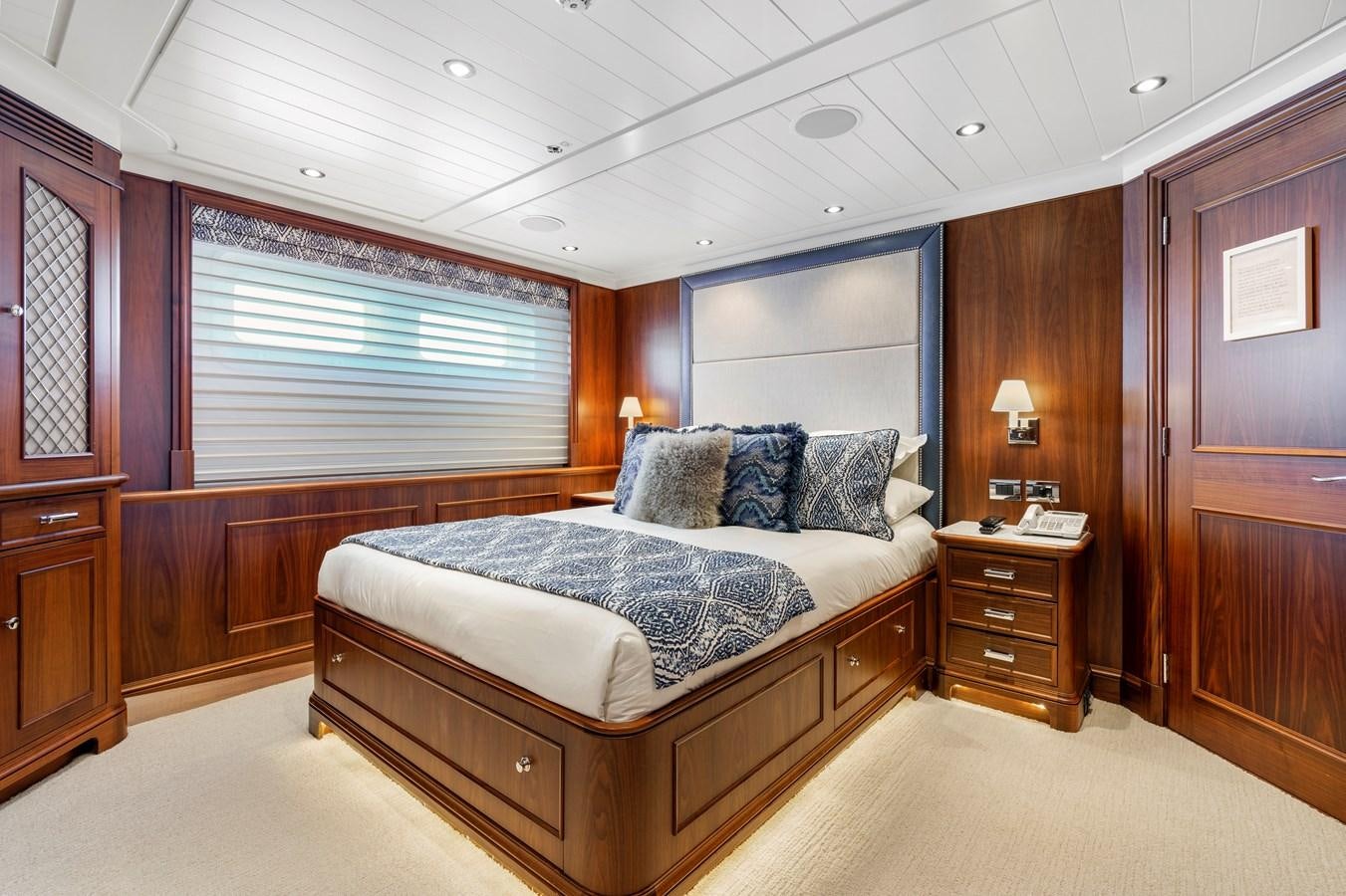 a bedroom with a bed and a dresser aboard BIG EASY Yacht for Charter