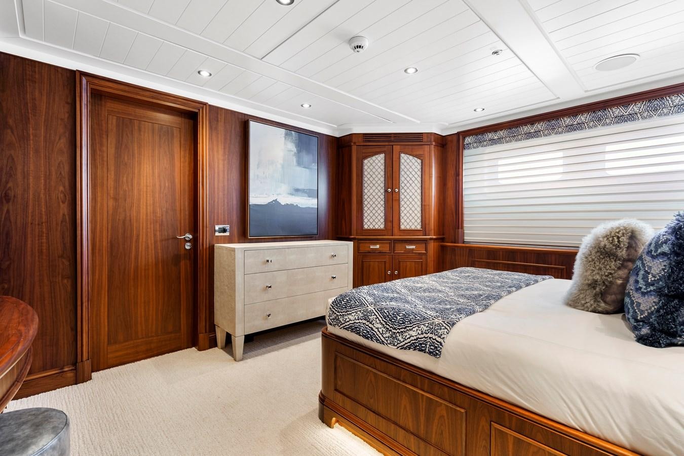 a bedroom with a bed and a wood cabinet aboard BIG EASY Yacht for Charter