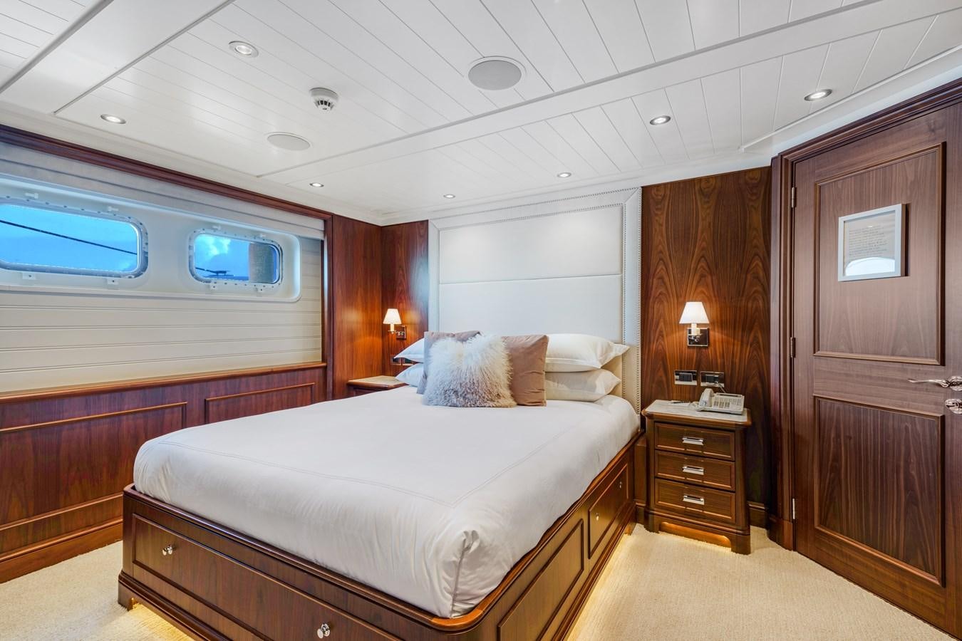 a bedroom with a bed and a dresser aboard BIG EASY Yacht for Charter