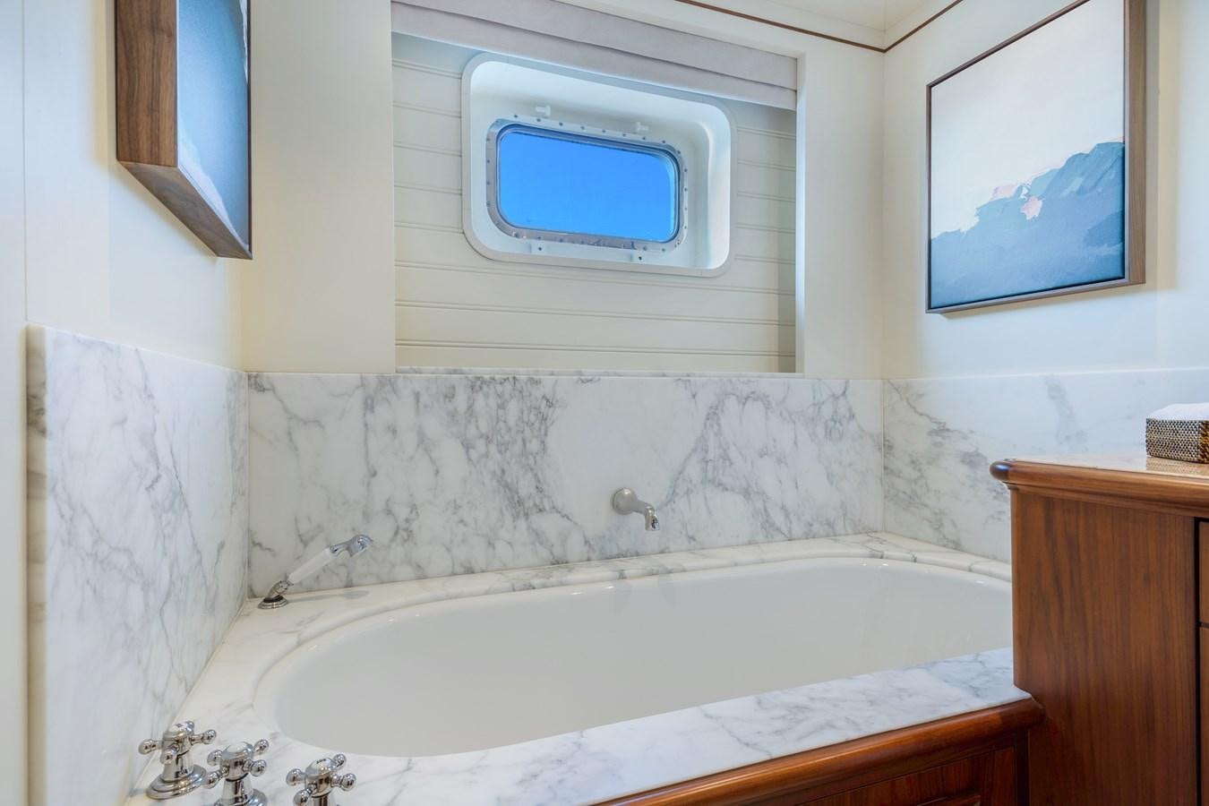a bathtub with a window aboard BIG EASY Yacht for Charter