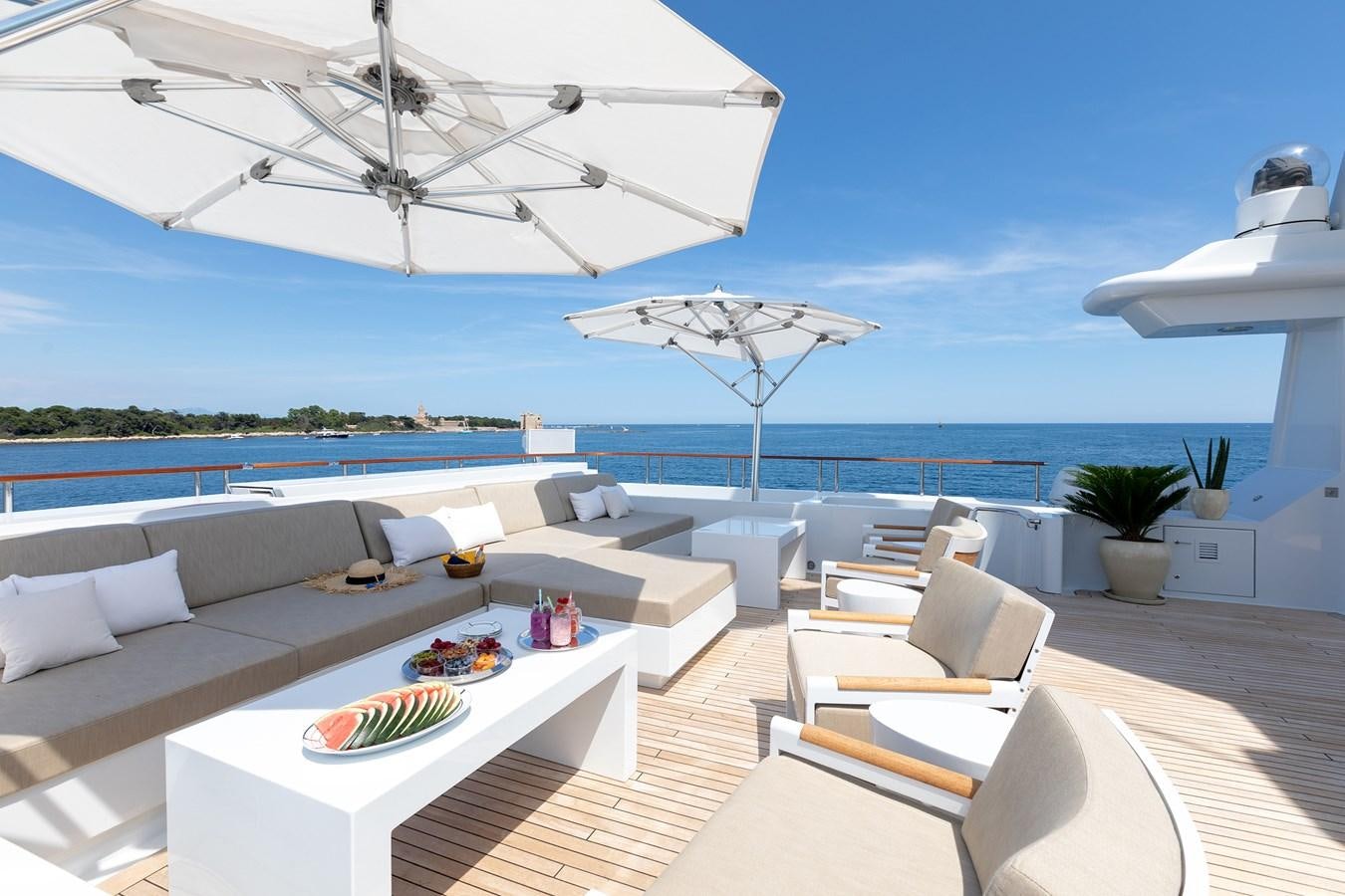 a modern living room with a large white umbrella aboard TREEHOUSE Yacht for Sale