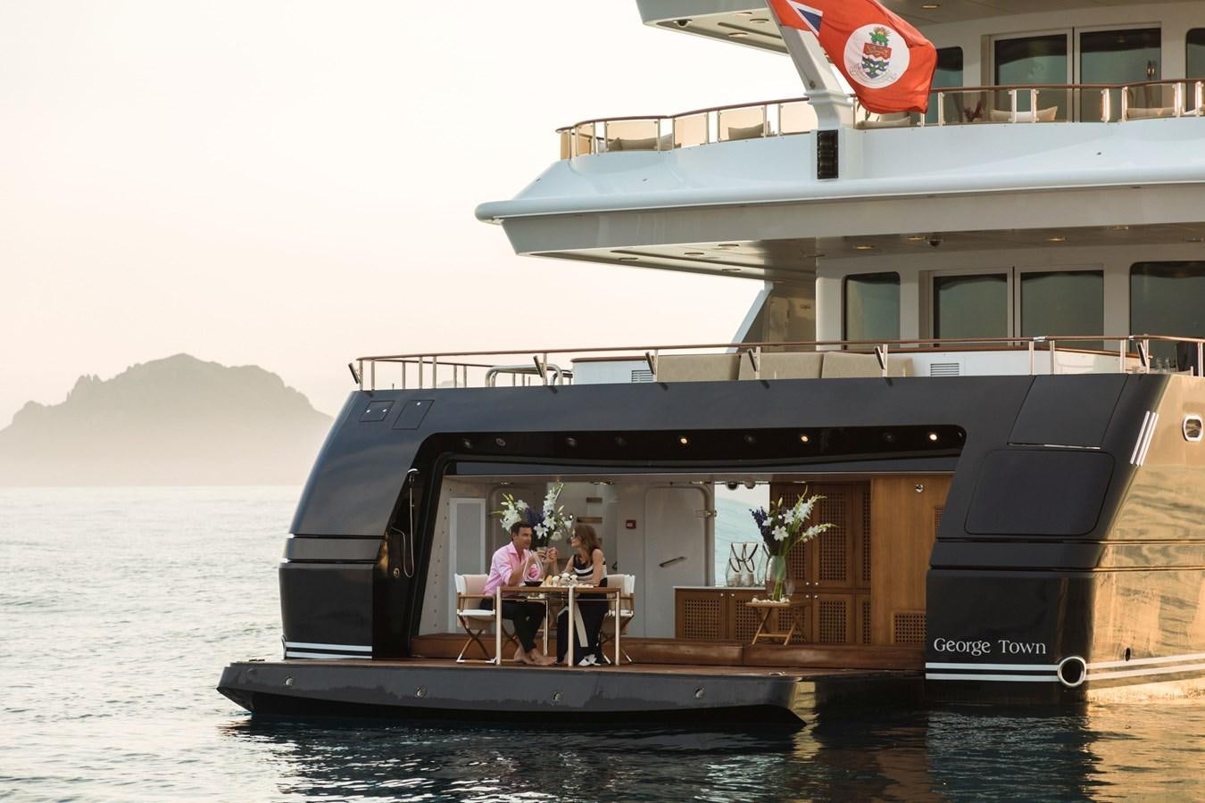 a group of people sitting at a table outside a building aboard TREEHOUSE Yacht for Sale