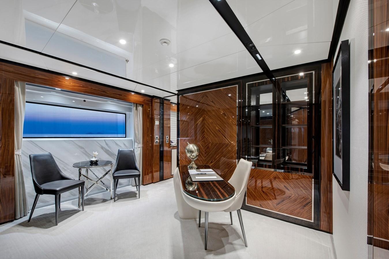 a room with a table chairs and a large window aboard STERN Yacht for Sale