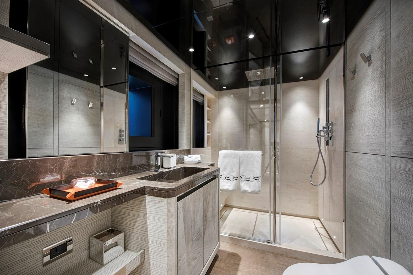 a bathroom with a shower and sinks aboard STERN Yacht for Sale