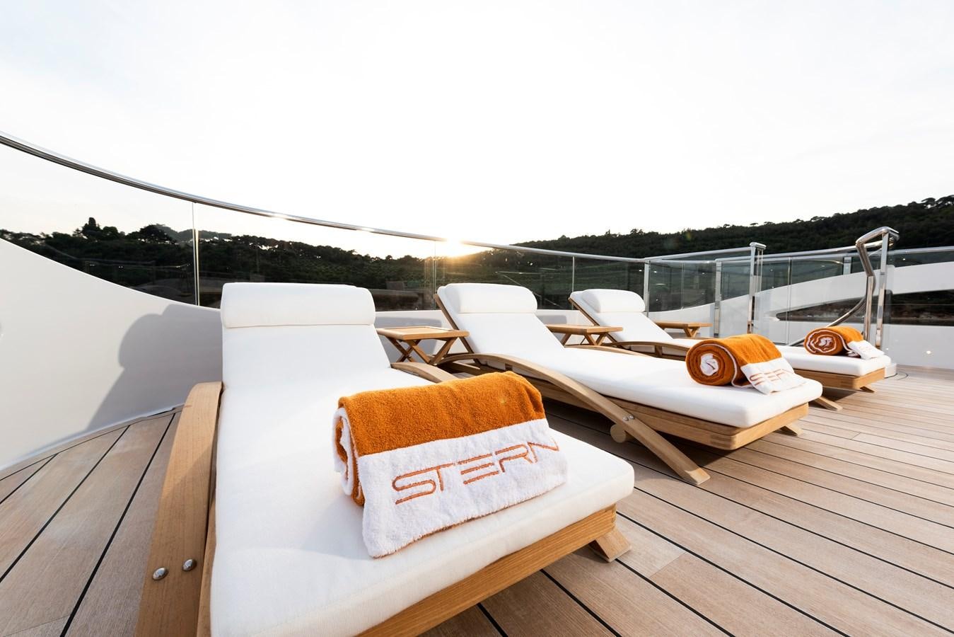 a deck with a table and chairs on it aboard STERN Yacht for Sale