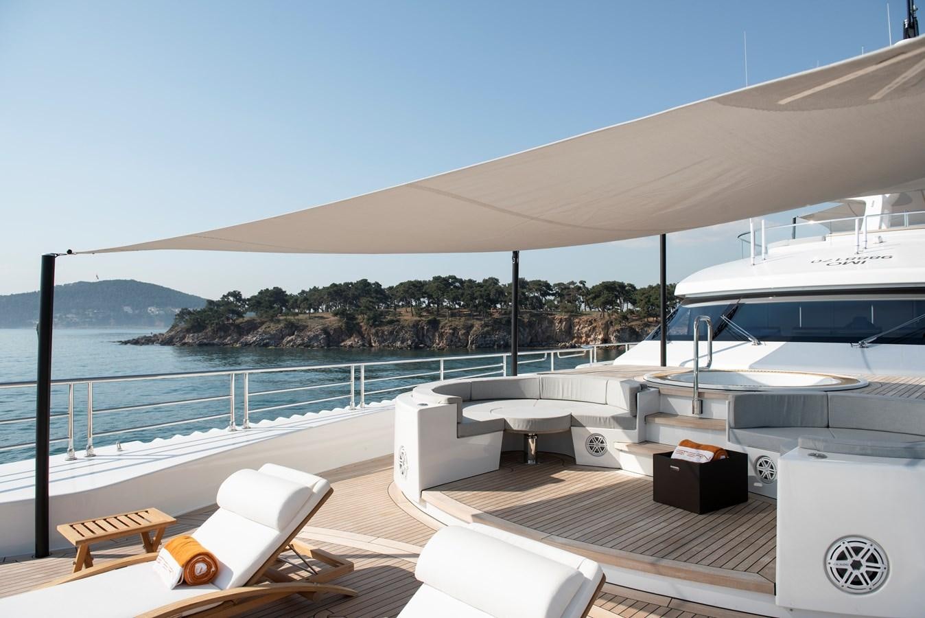 a deck with a view of the ocean and a large boat aboard STERN Yacht for Sale