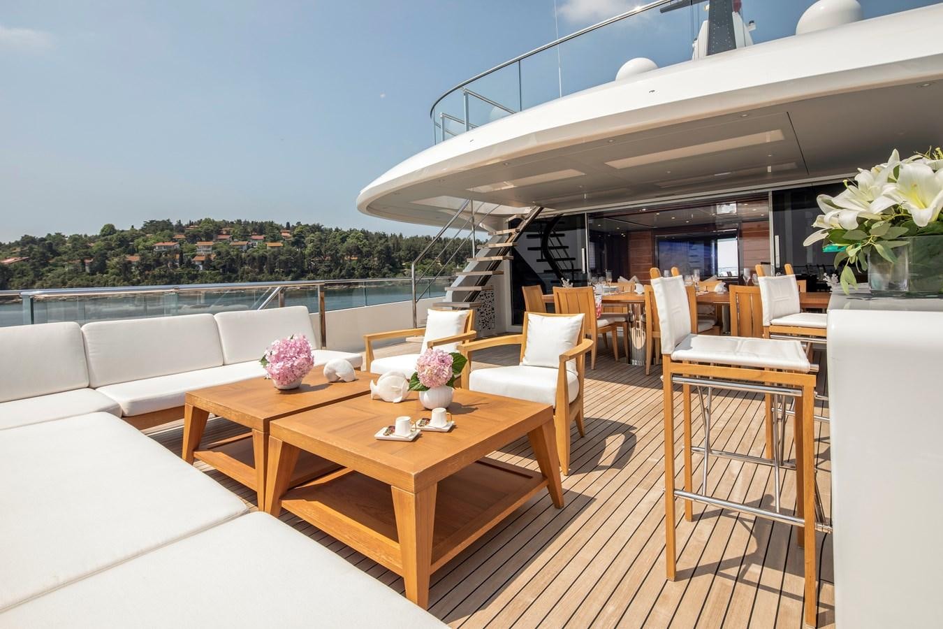 a table and chairs on a deck aboard STERN Yacht for Sale