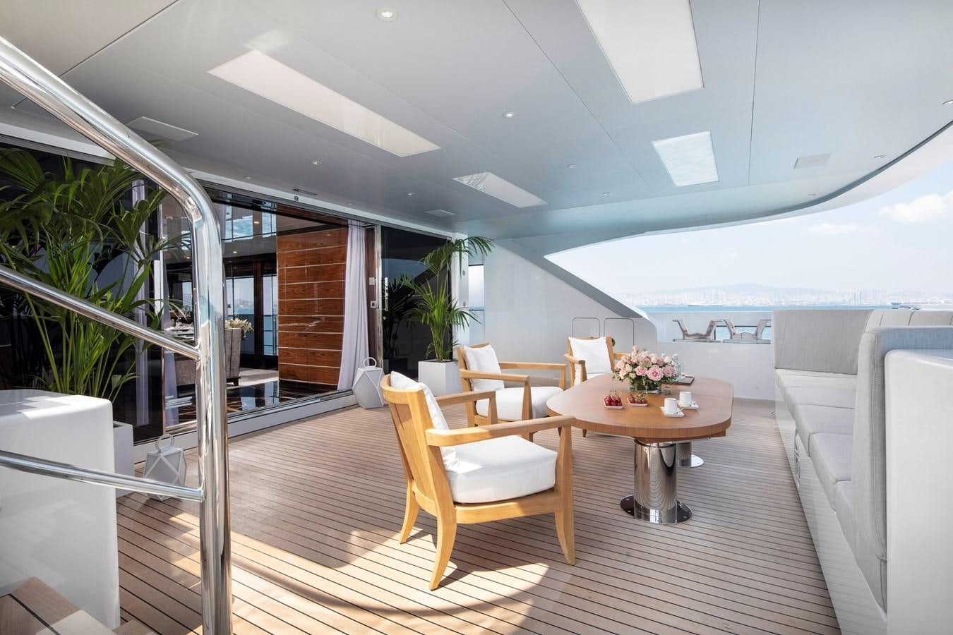 a room with a table chairs and plants aboard STERN Yacht for Sale