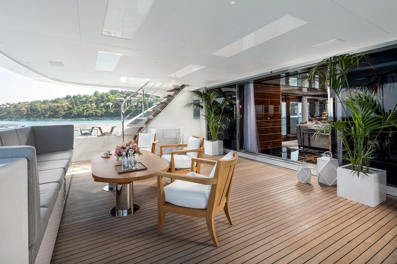 a room with a table chairs and plants aboard STERN Yacht for Sale