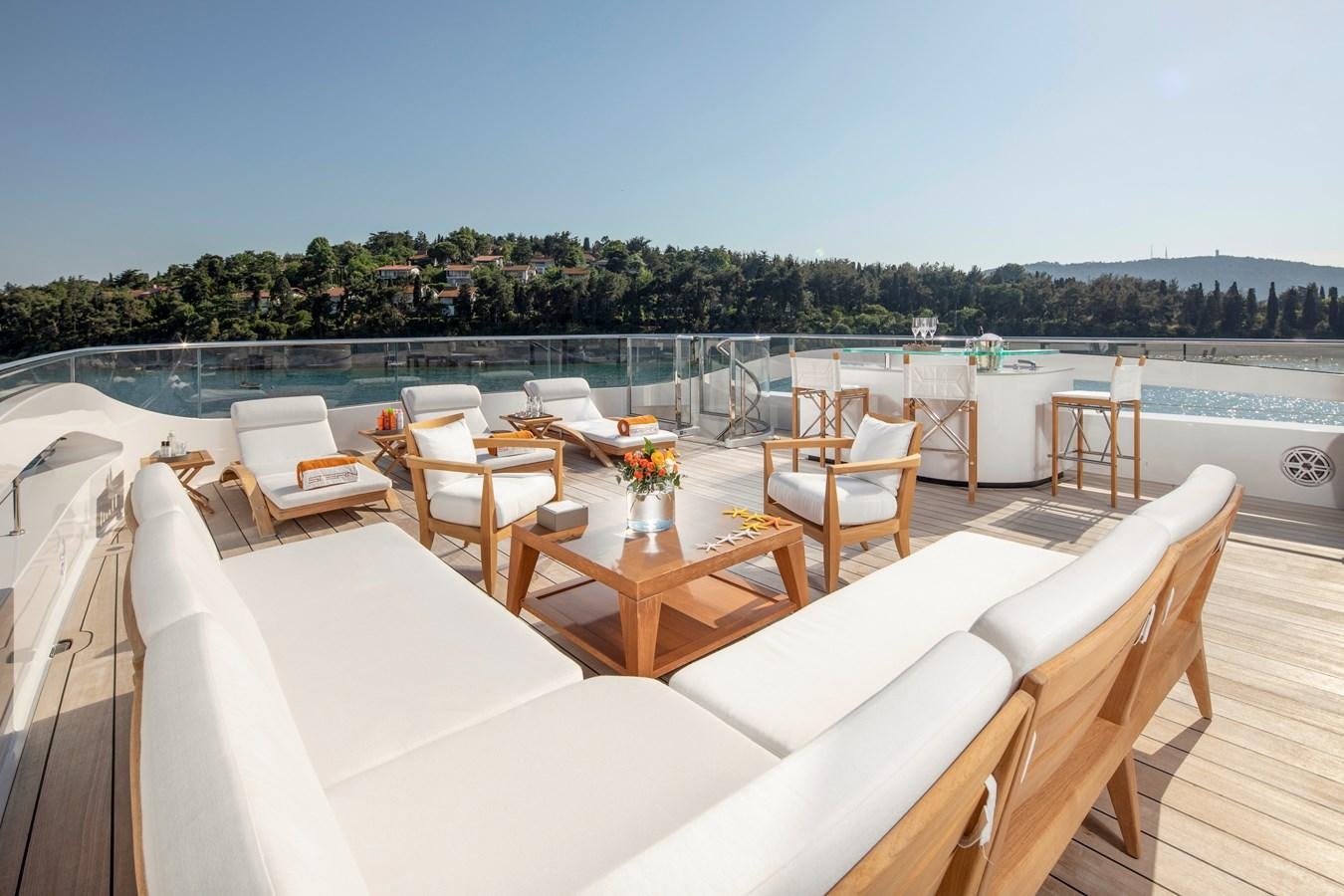 a table and chairs on a deck aboard STERN Yacht for Sale