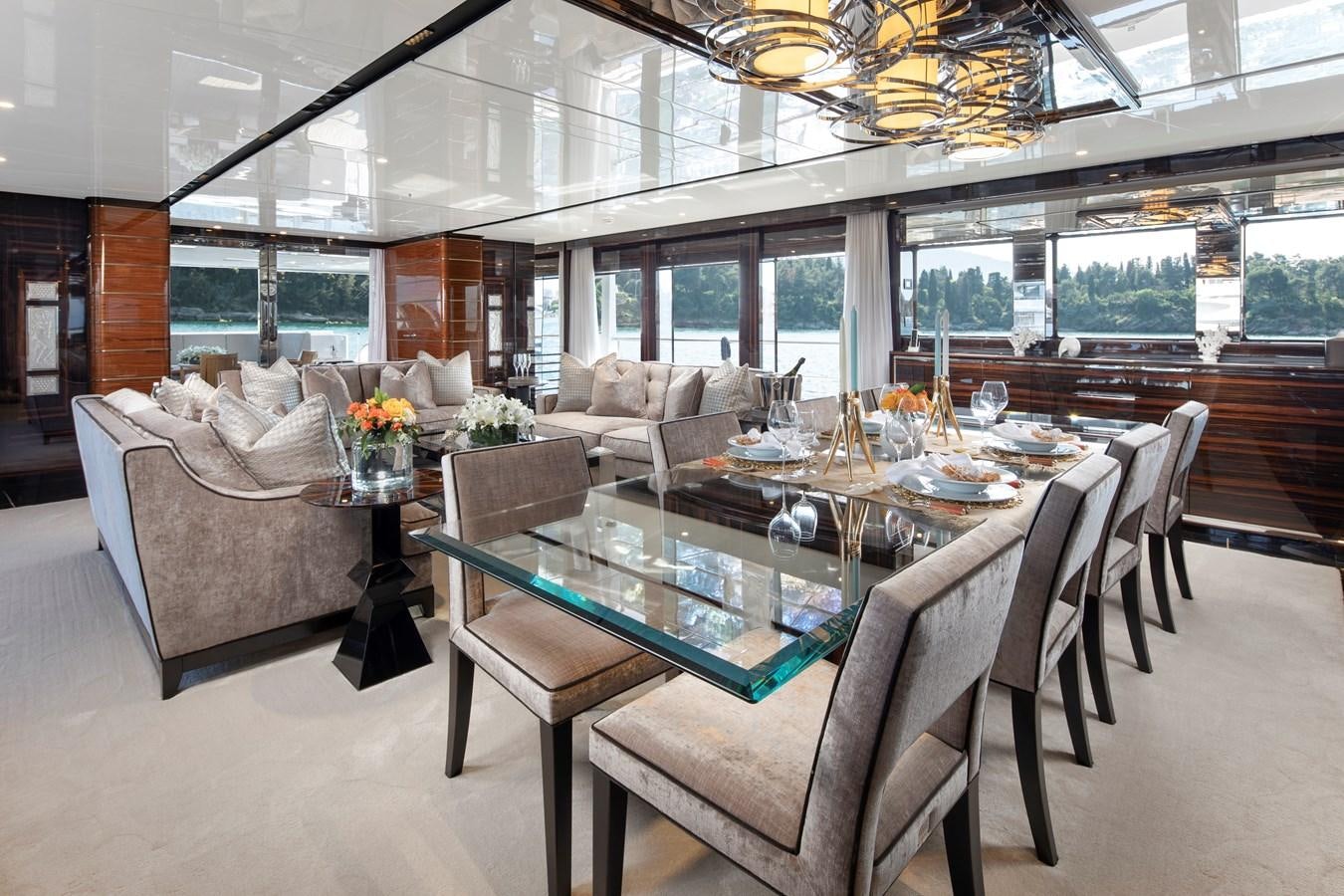 a large living room with a large table and chairs aboard STERN Yacht for Sale