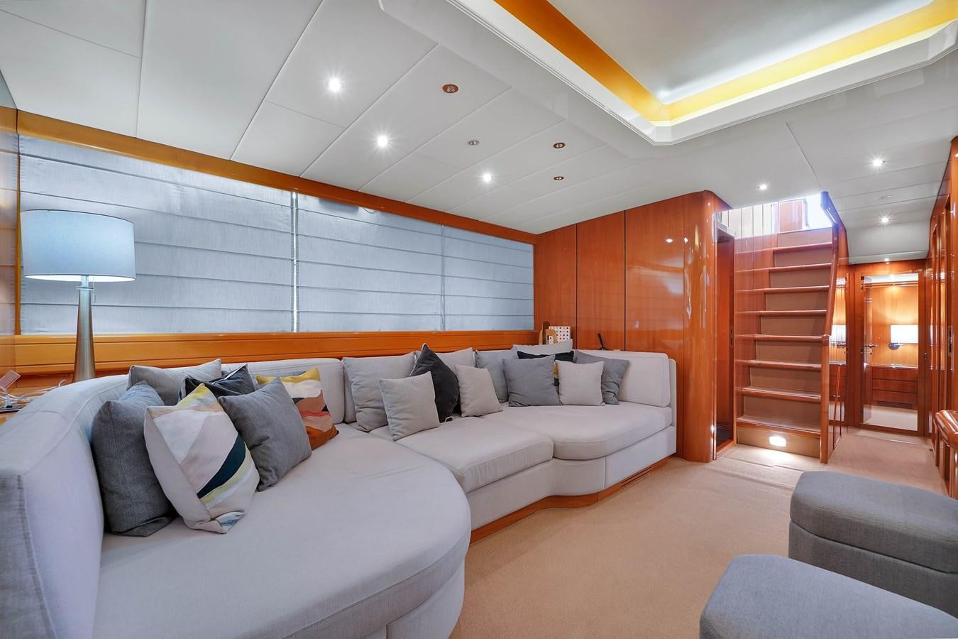 a living room with a couch and a wood door aboard HAKUNA MATATA Yacht for Sale