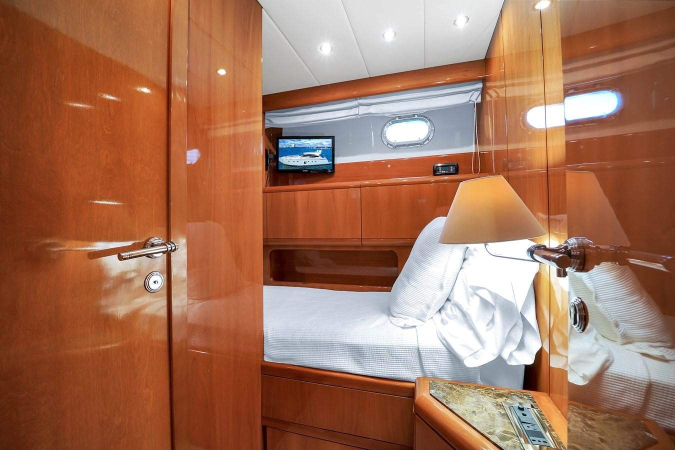 a room with a bed and a wood door aboard HAKUNA MATATA Yacht for Sale