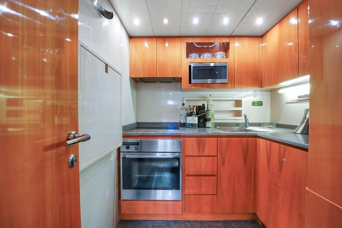 a kitchen with wooden cabinets aboard HAKUNA MATATA Yacht for Sale