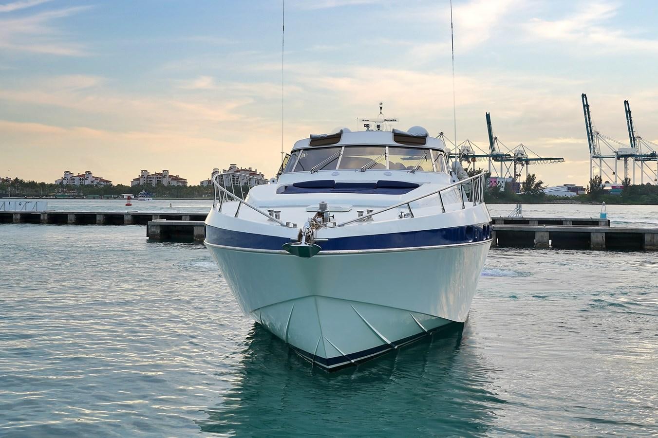 a large white boat in a harbor aboard HAKUNA MATATA Yacht for Sale