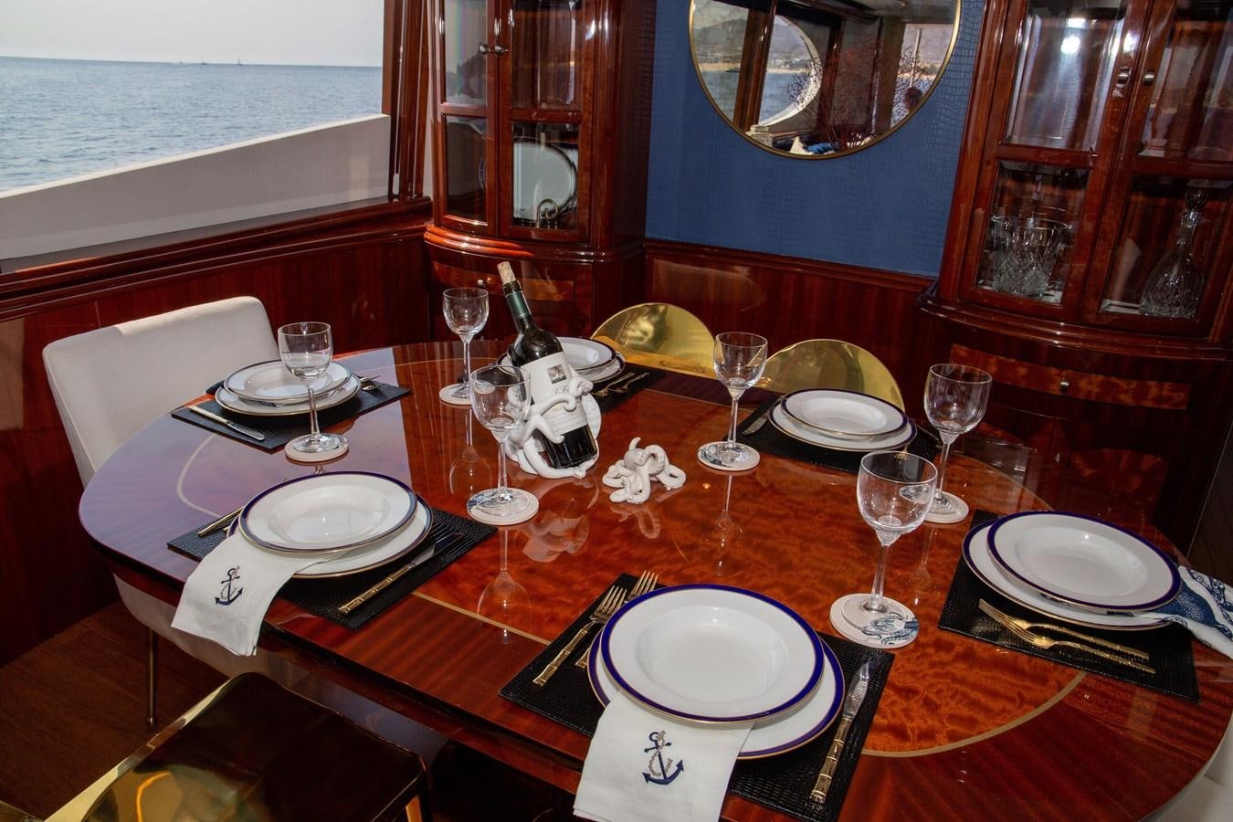 a table with plates and glasses aboard LAZZARA 80' Yacht for Sale
