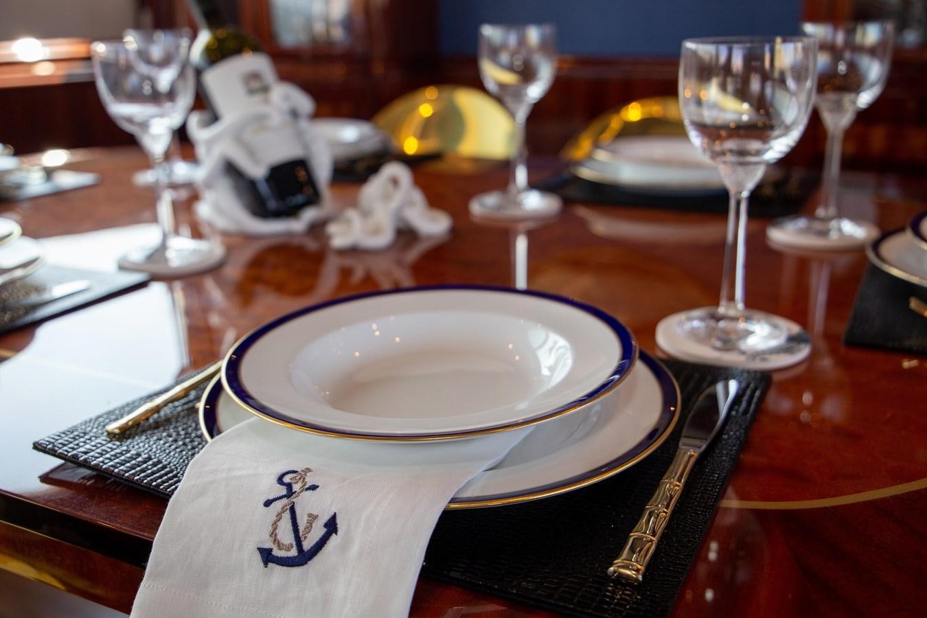 a table with plates and glasses aboard LAZZARA 80' Yacht for Sale