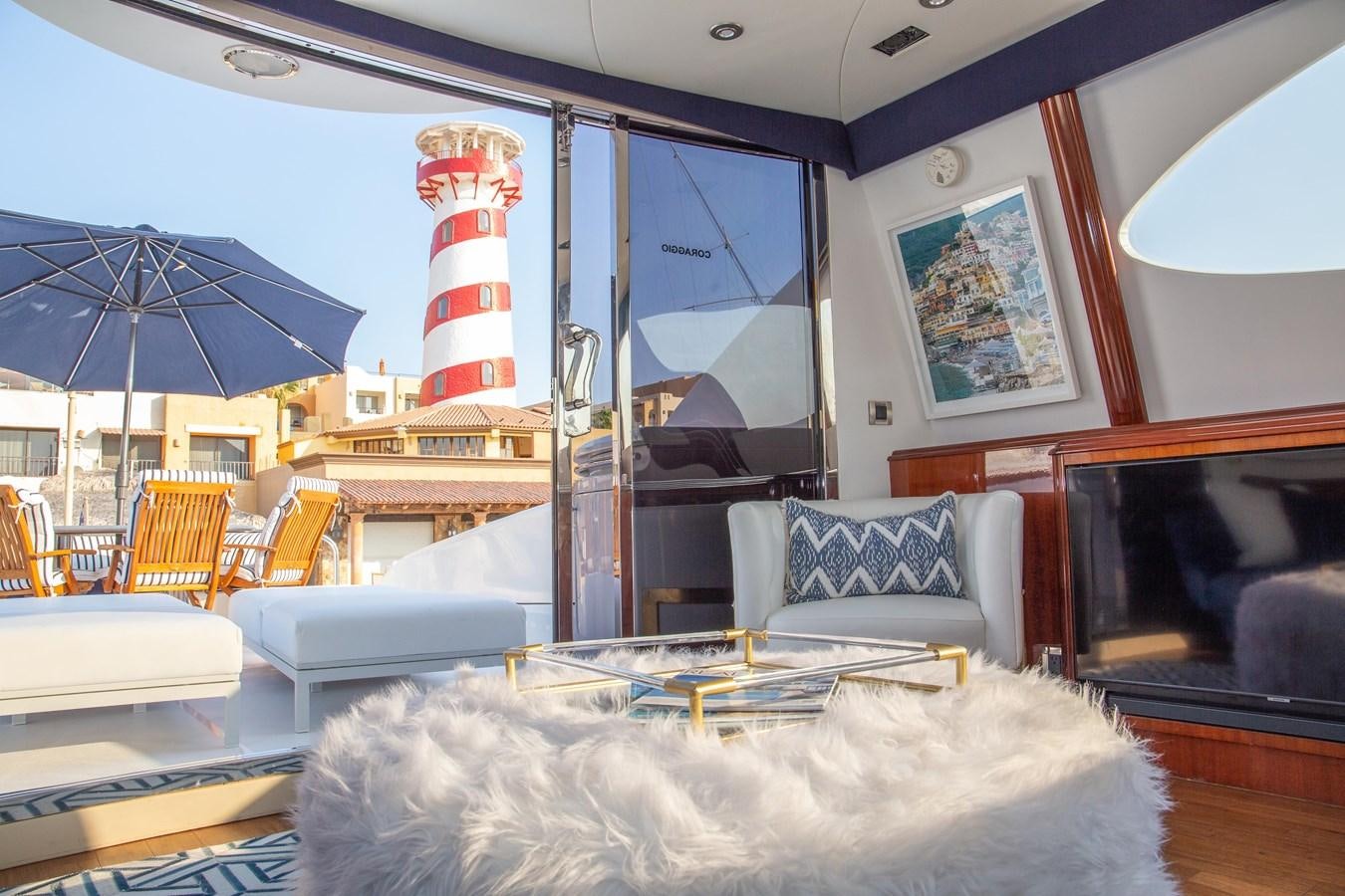 a room with a table chairs and a television aboard LAZZARA 80' Yacht for Sale