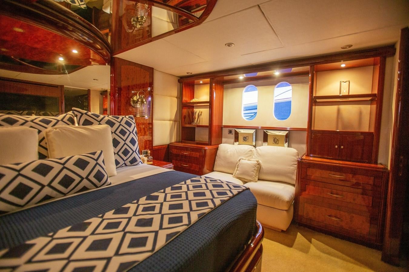 a bedroom with a bed and a dresser aboard LAZZARA 80' Yacht for Sale