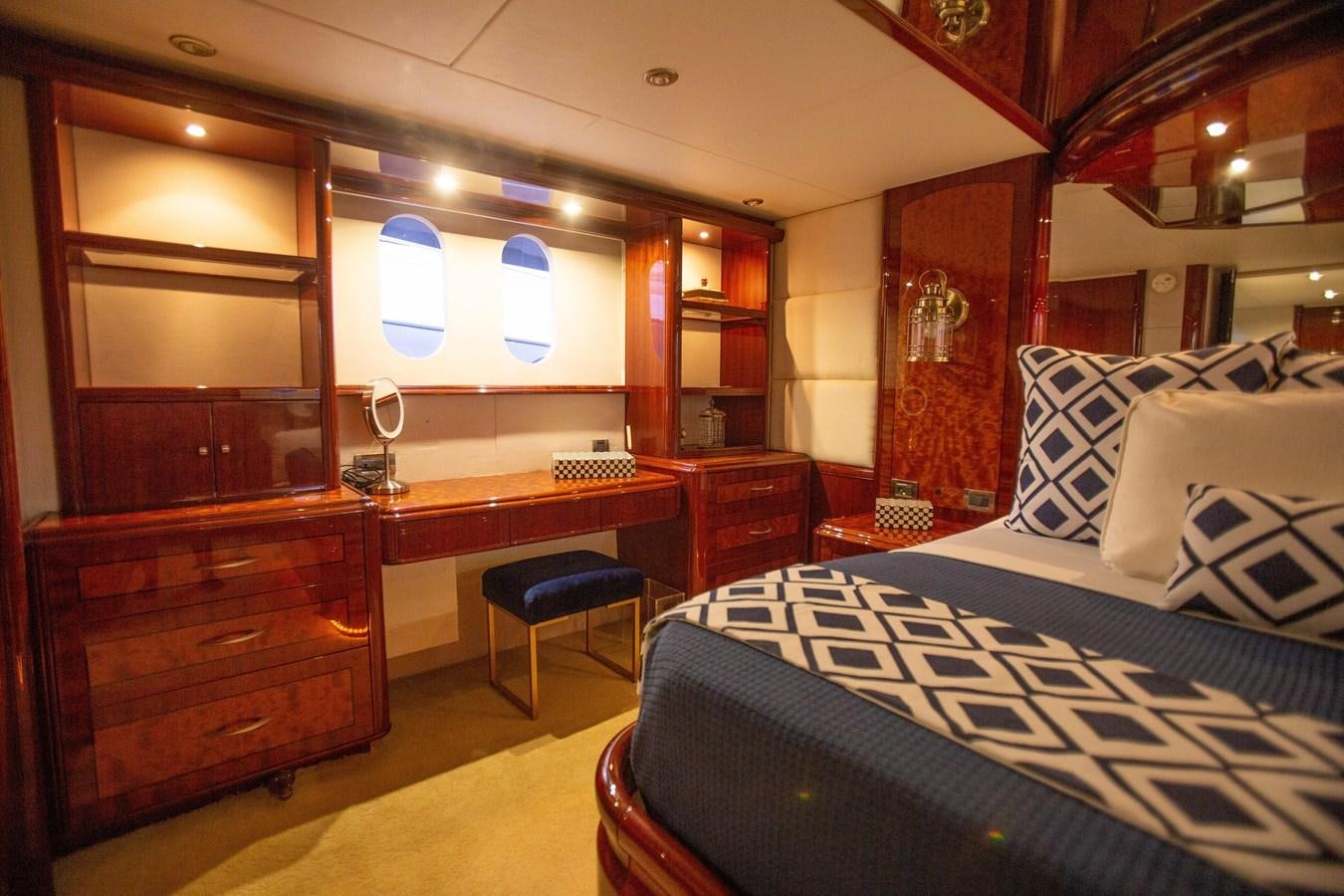 a room with a bed and desk aboard LAZZARA 80' Yacht for Sale