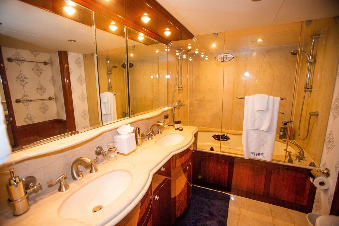 a bathroom with two sinks and a large mirror aboard LAZZARA 80' Yacht for Sale