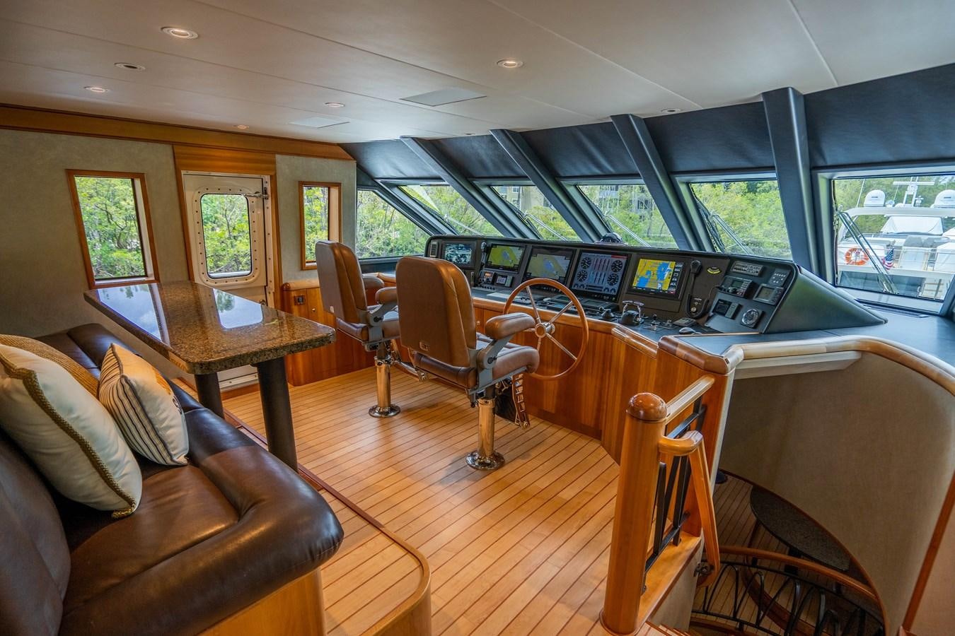 a room with a couch and a table with chairs and a tv aboard SHORT GAME Yacht for Sale