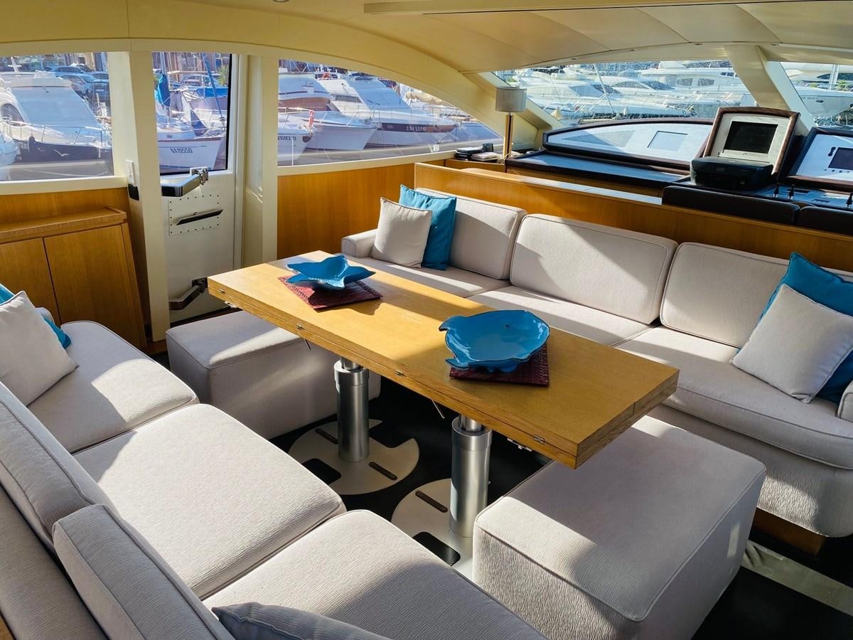 a room with a couch and a table with a laptop on it aboard DEA Yacht for Sale
