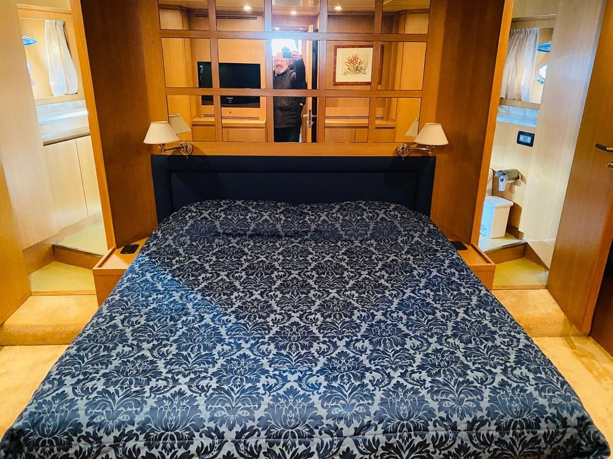a bed with a blue sheet aboard DEA Yacht for Sale