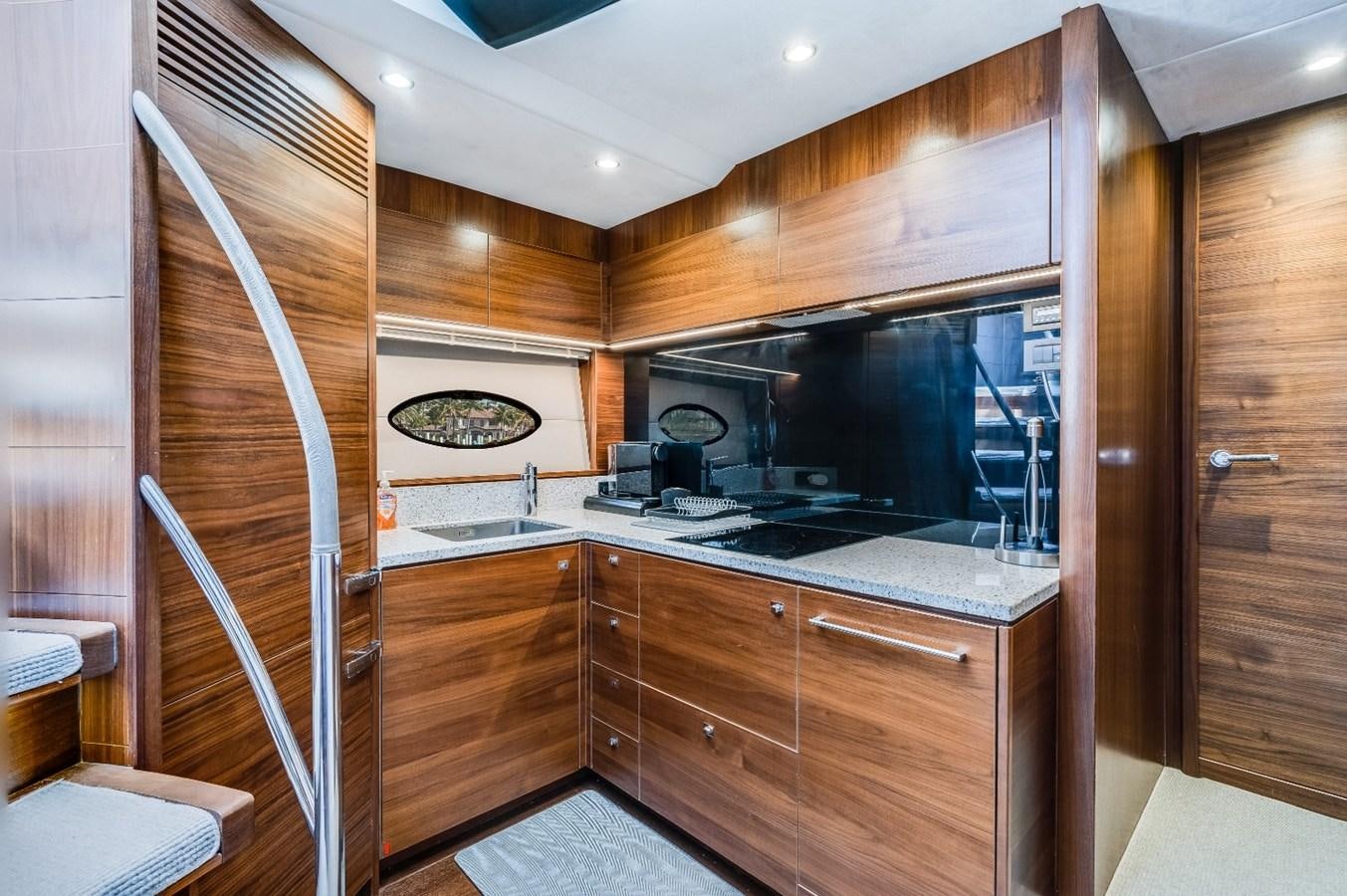 a kitchen with wooden cabinets aboard SOL INVICTUS Yacht for Sale