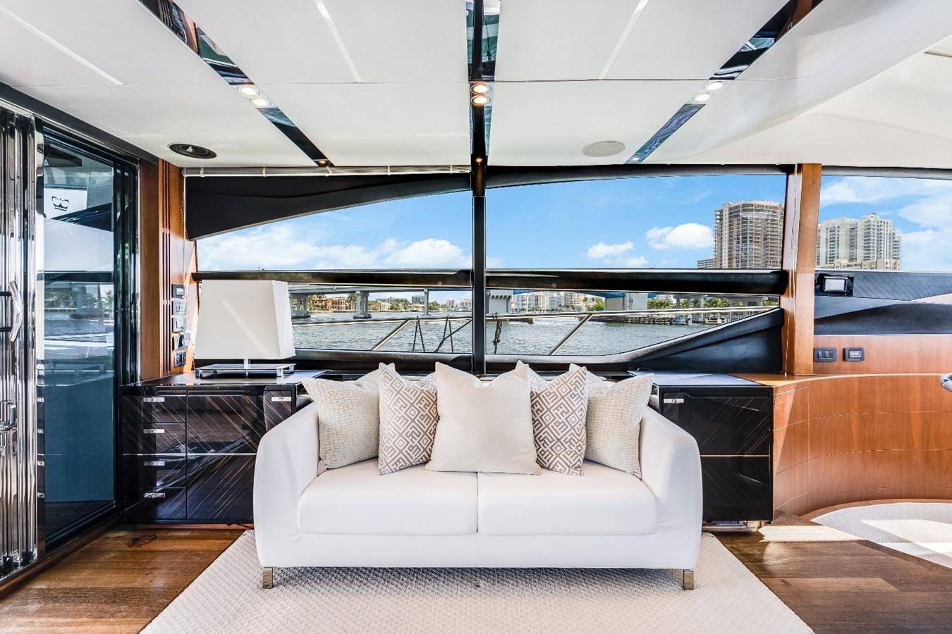 a white couch in a room with a large window overlooking a city aboard SOL INVICTUS Yacht for Sale