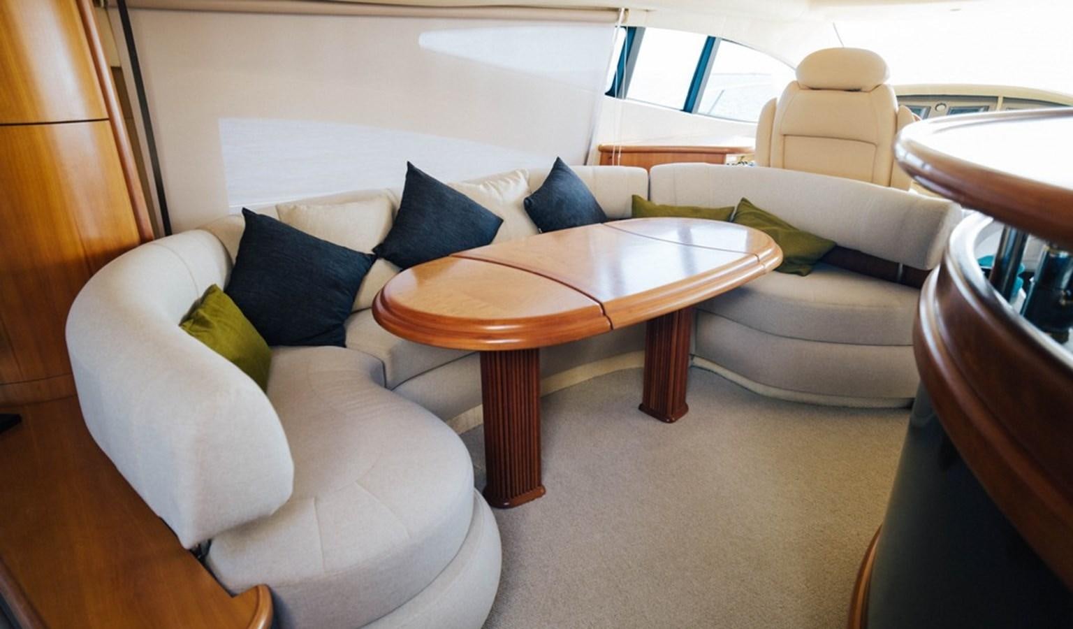 a living room with a table and couches aboard FOUNDATION  Yacht for Sale