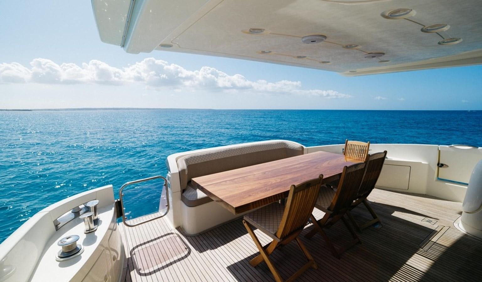 a table and chairs on a deck overlooking the ocean aboard FOUNDATION  Yacht for Sale