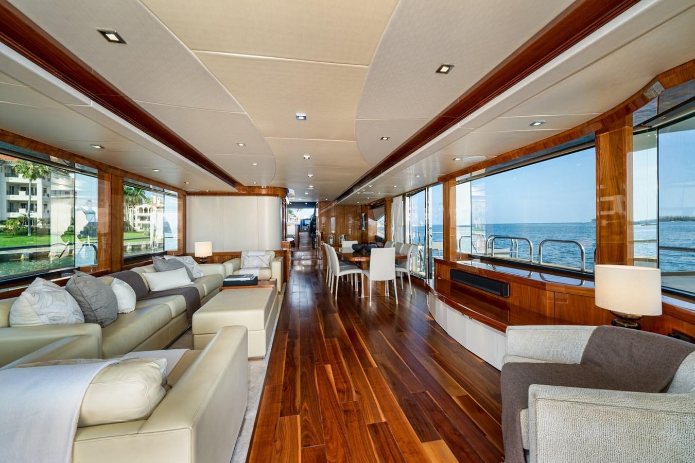 a large living room with a wood floor and a large window aboard 2015 SUNSEEKER 92' Yacht for Sale