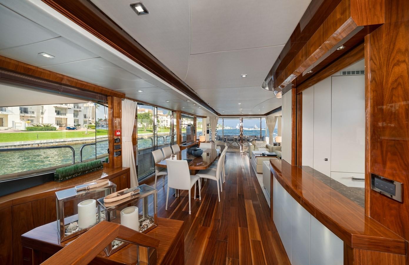 a wood deck with a wood railing and a large window with a view of the water and trees aboard 2015 SUNSEEKER 92' Yacht for Sale