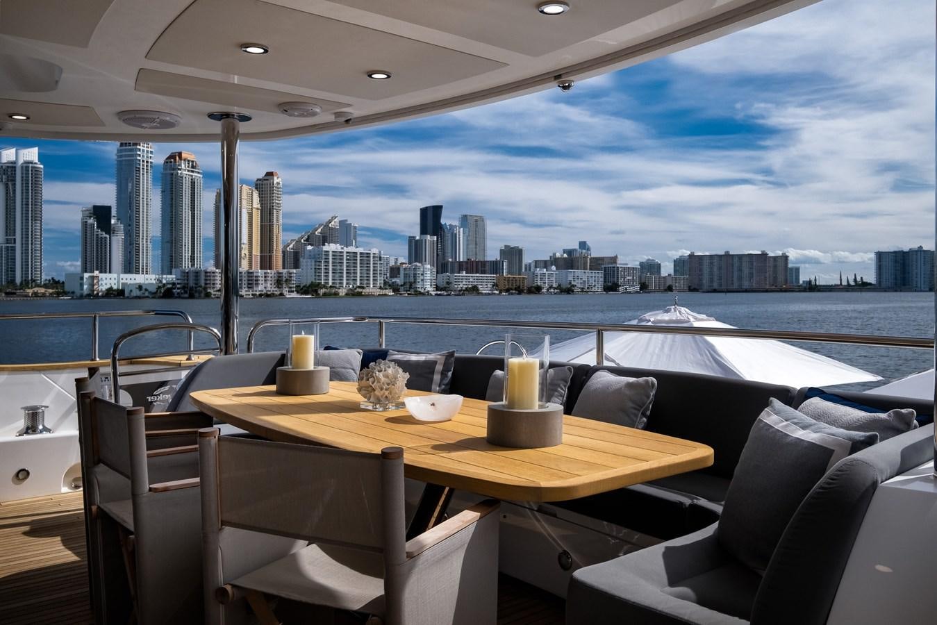 a table with chairs and a view of a city aboard 2015 SUNSEEKER 92' Yacht for Sale