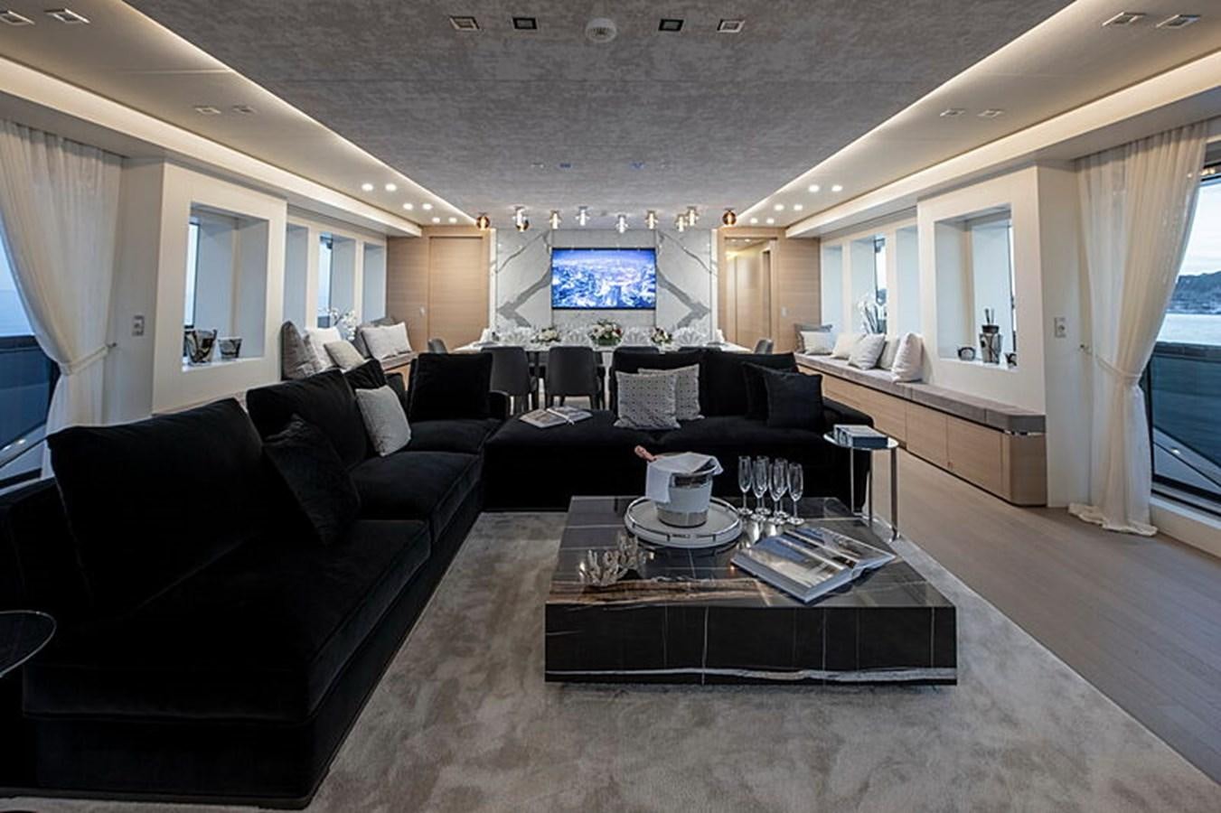 a living room with black couches and a tv aboard NEXT Yacht for Sale