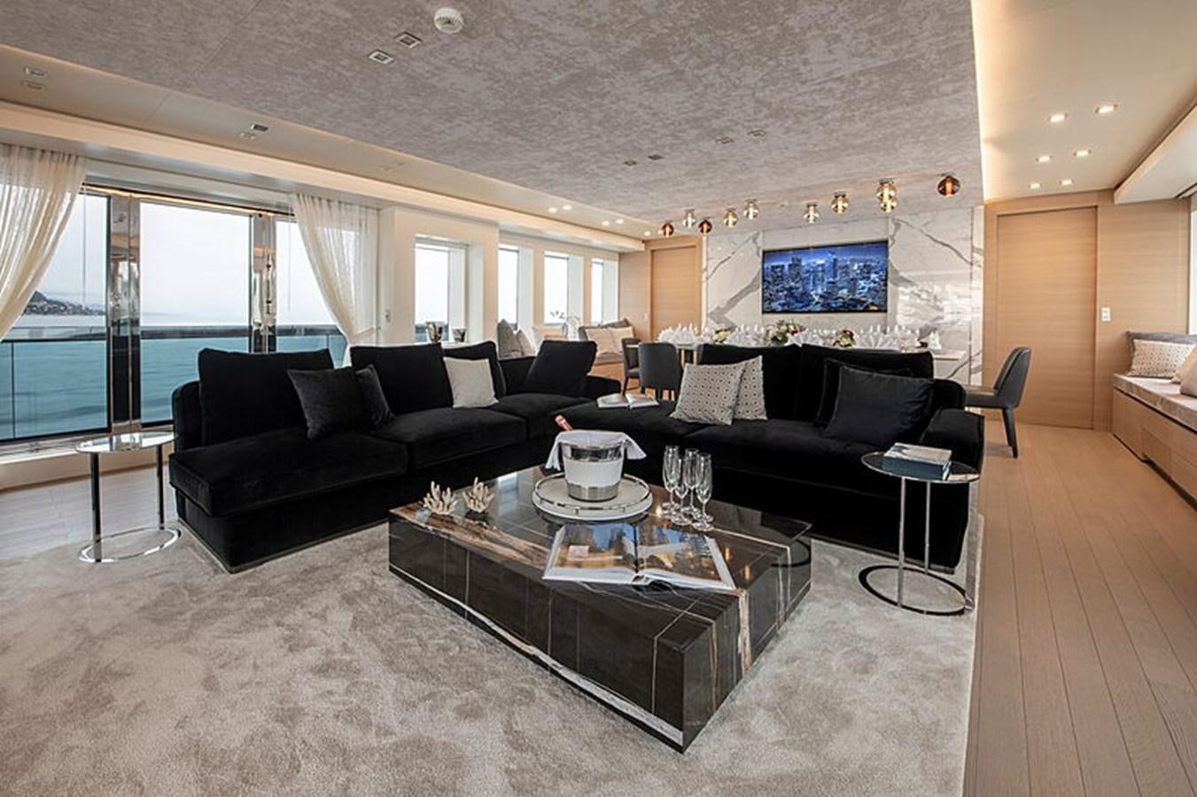 a living room with leather couches and a large screen tv aboard NEXT Yacht for Sale