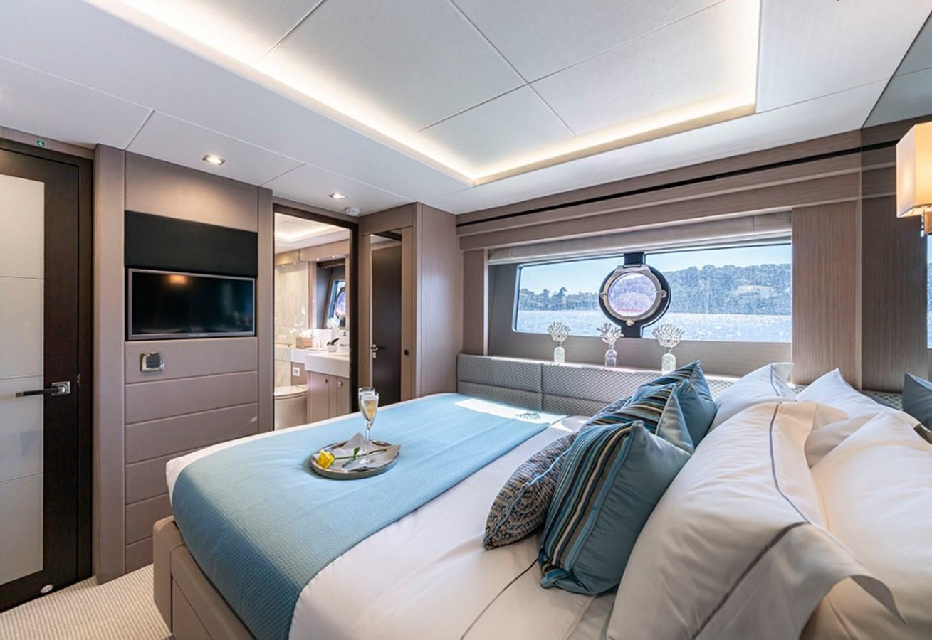 a bedroom with a blue table aboard HERO Yacht for Sale