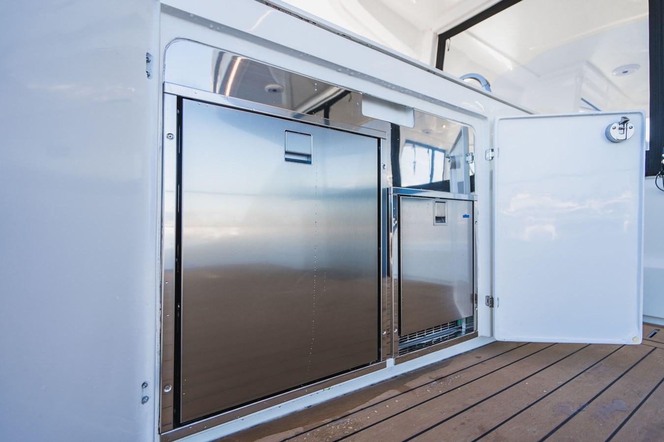 a large metal refrigerator next to a white refrigerator aboard PLANE TO SEA Yacht for Sale