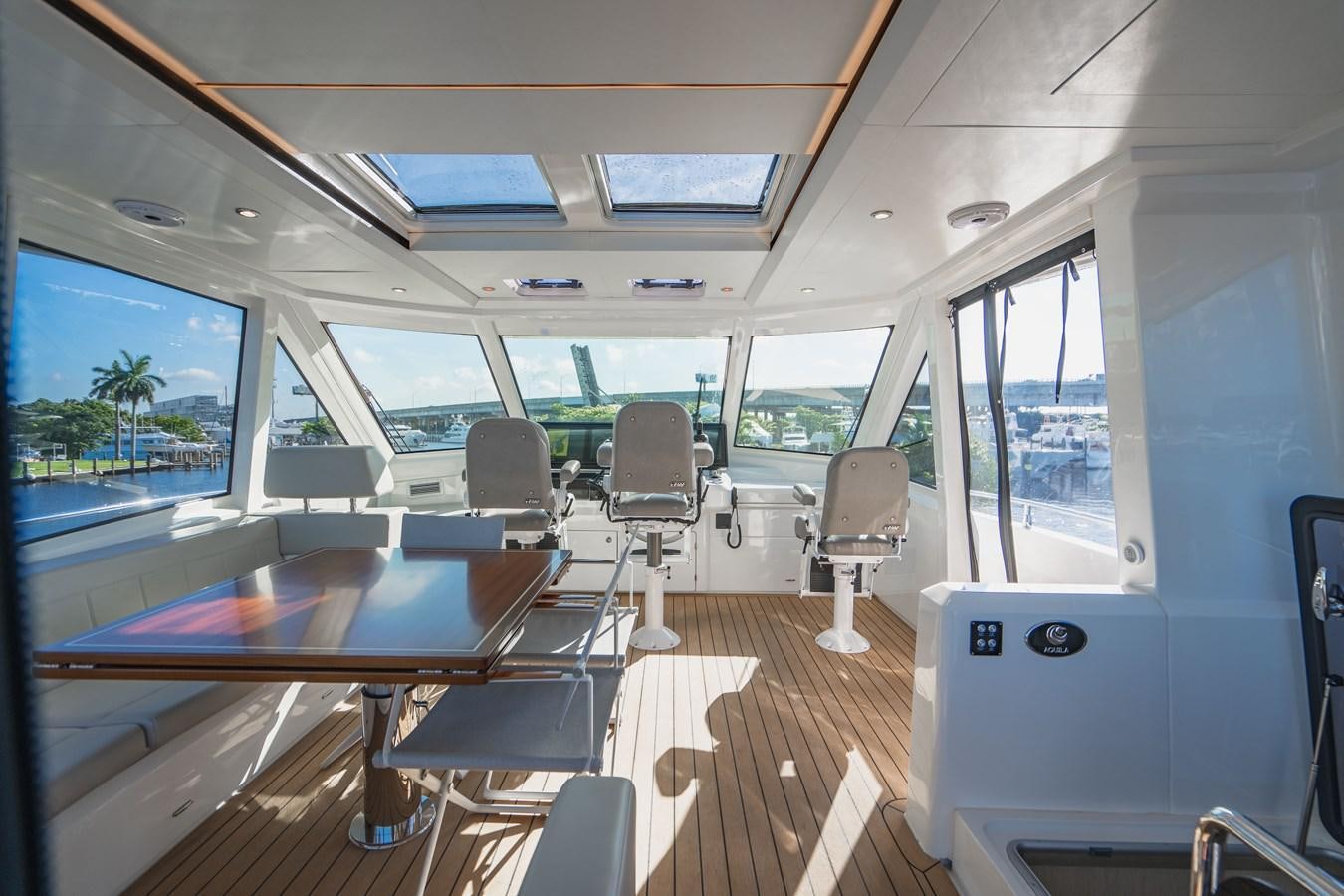 inside of a vehicle with a table and chairs aboard PLANE TO SEA Yacht for Sale