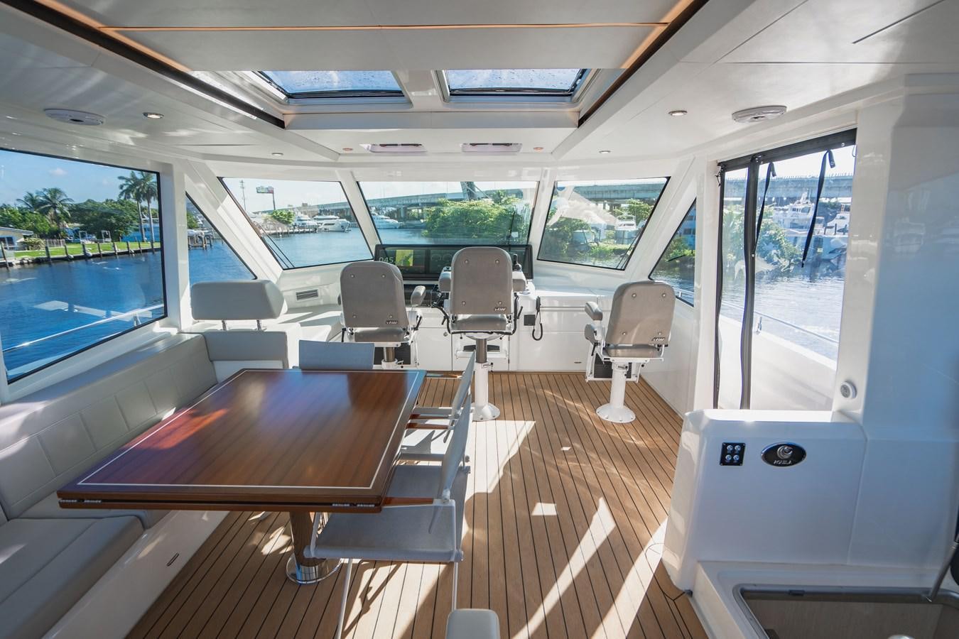 inside of a vehicle with a table and chairs aboard PLANE TO SEA Yacht for Sale