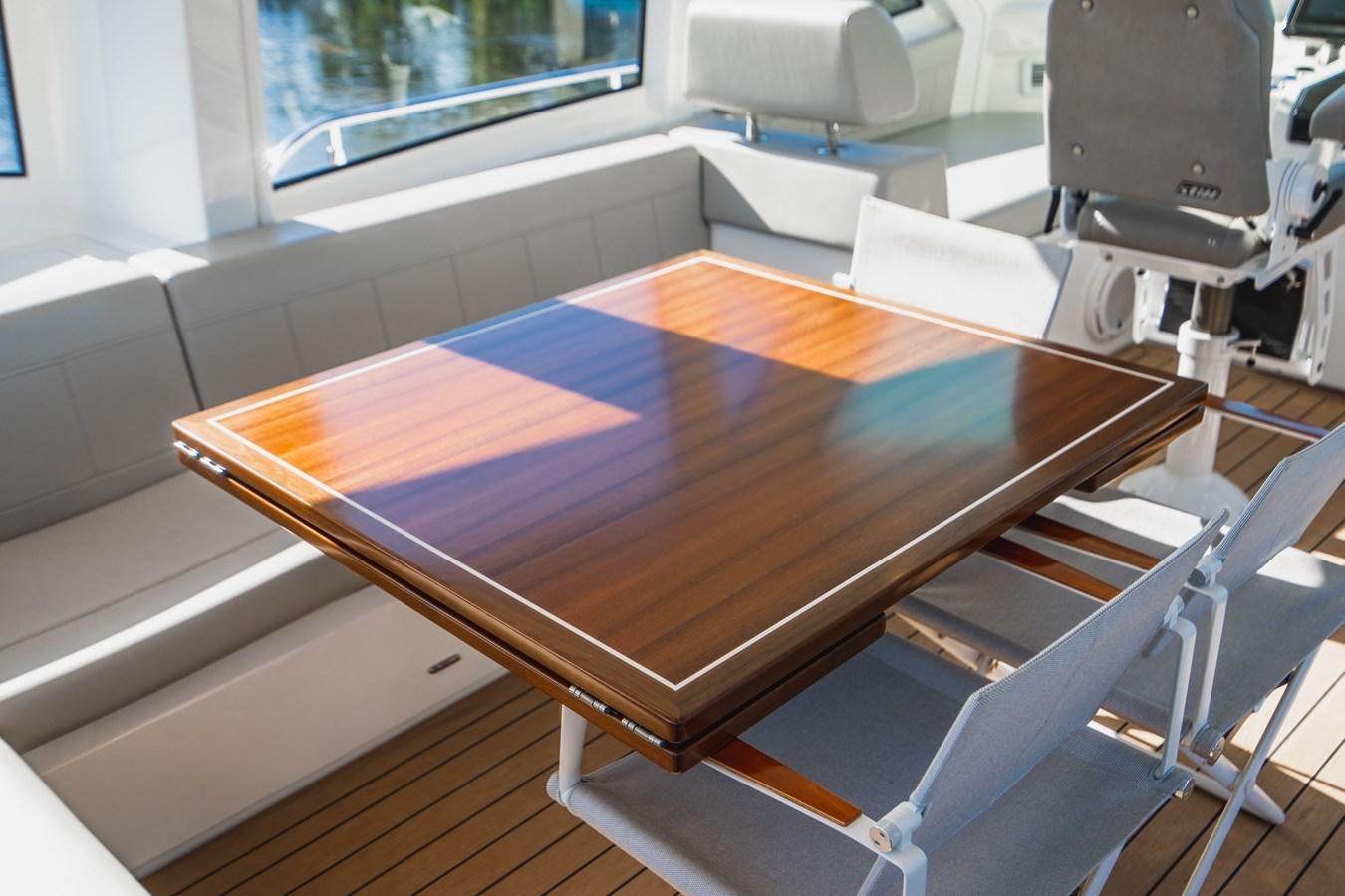 a wood table with a chair aboard PLANE TO SEA Yacht for Sale