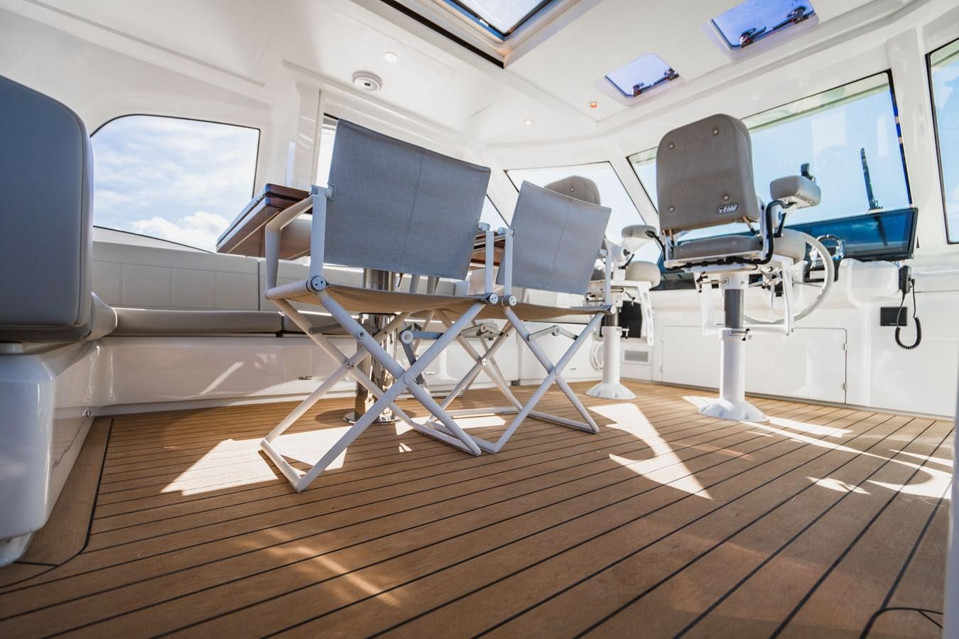 a room with a large window and a desk with computers on it aboard PLANE TO SEA Yacht for Sale