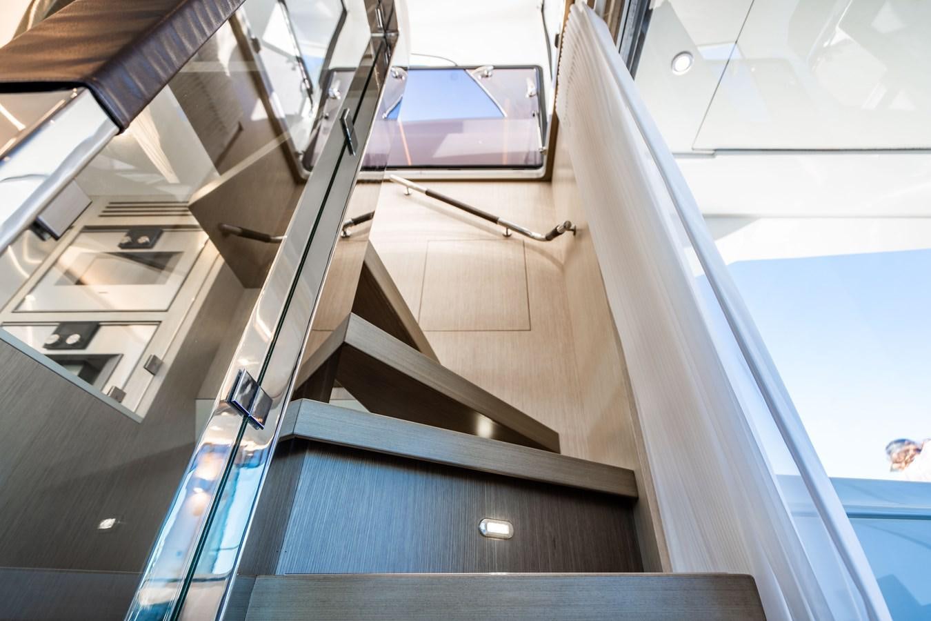 a view looking up at the sky from the bottom of a spiral staircase aboard PLANE TO SEA Yacht for Sale
